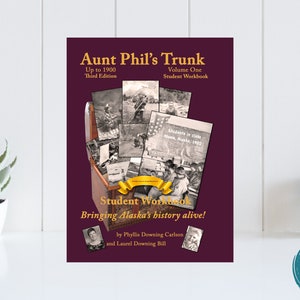 May include: A burgundy book cover with the title "Aunt Phil's Trunk: Up to 1900, Third Edition, Volume One, Student Workbook". The cover features a vintage wooden trunk with a collage of old photographs inside. The text "Bringing Alaska's history alive!" is written in gold lettering. The authors are Phyllis Downing Carlson and Laurel Downing Bill.