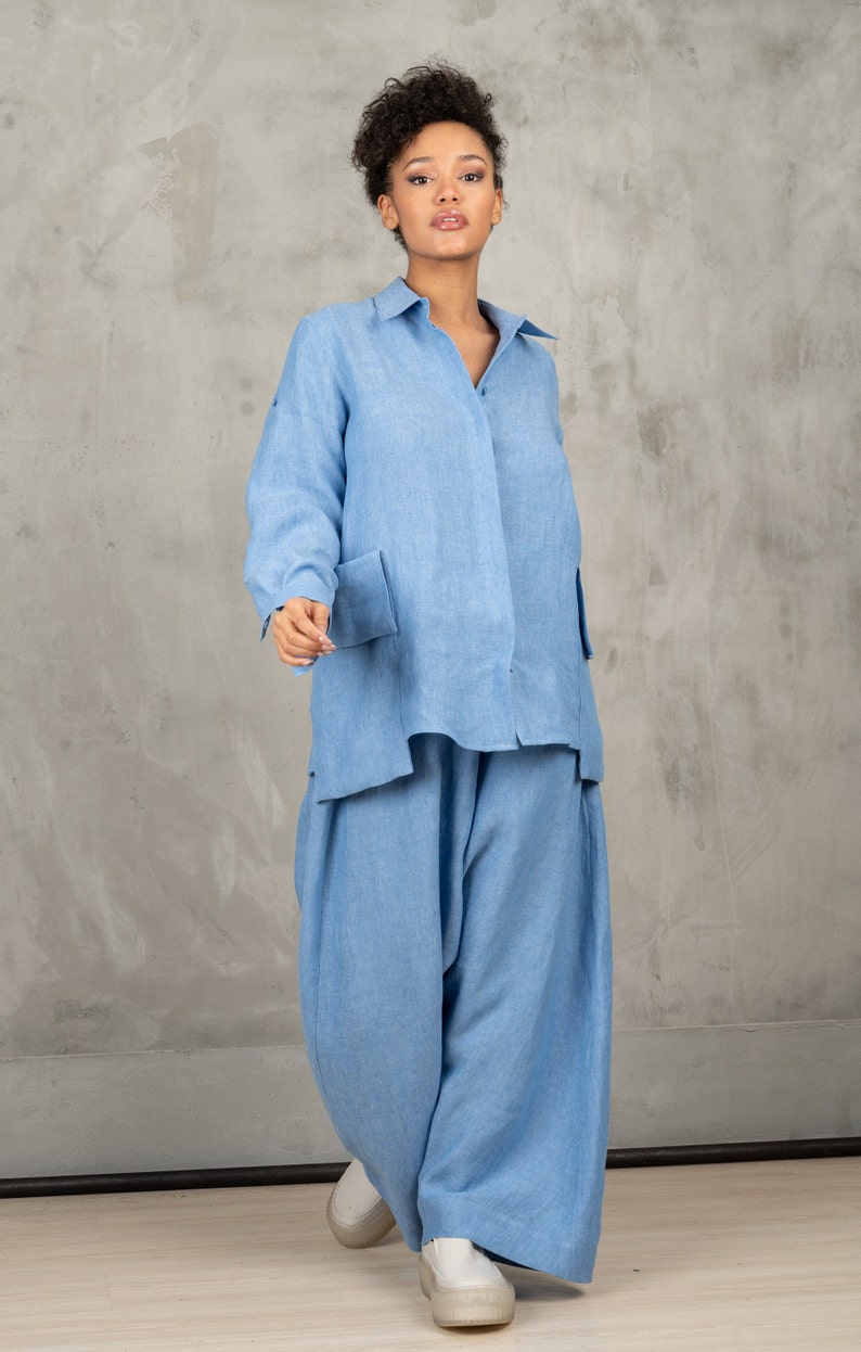 May include: A light blue linen shirt and pants set. The shirt has a button-down collar and long sleeves. The pants are wide-legged and have a relaxed fit.