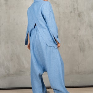 May include: A light blue linen pantsuit with a long-sleeved shirt and wide-leg pants. The shirt has a back cutout and the pants have a loose, flowing fit.