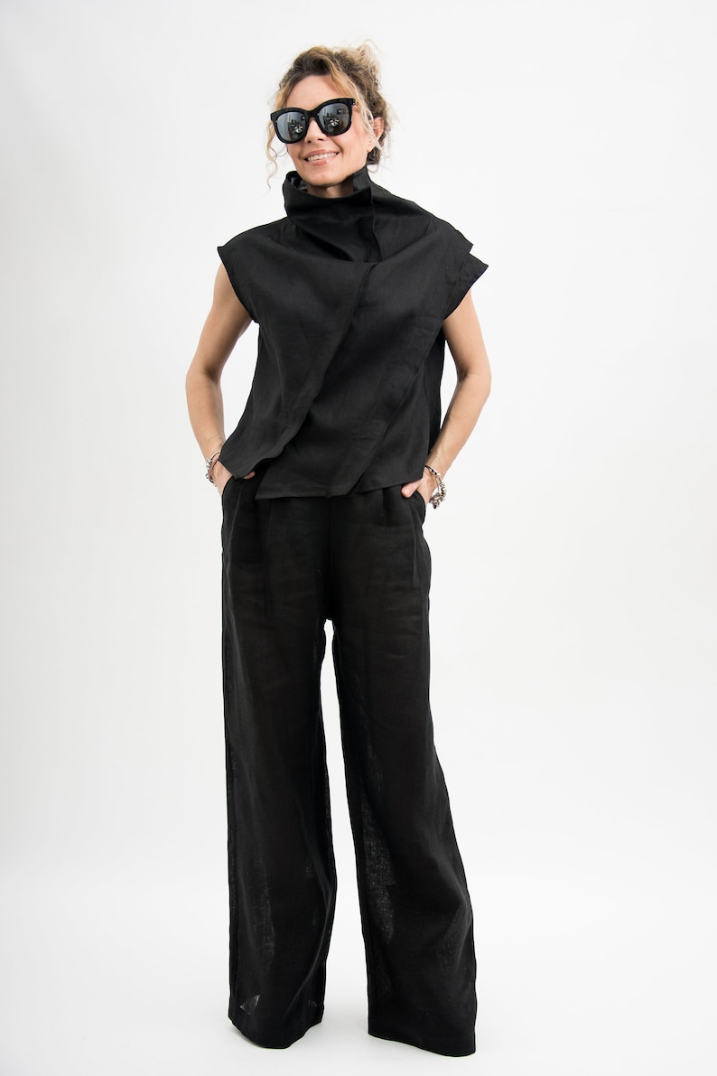 May include: A black mock neck top with a draped design and wide-leg pants. The outfit is made of a linen fabric.