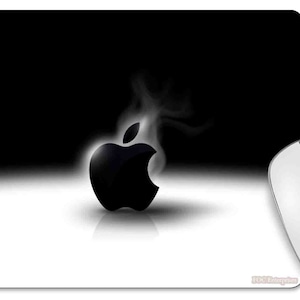 May include: A black and white mouse pad featuring the Apple logo with a vapor effect. A white wireless mouse and a white mug filled with coffee are also in the image. The mouse pad has a gradient design.