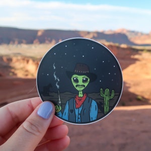 Cowboy Alien Vinyl Sticker Featuring Desert Scene and Cactus. Perfect for any Alien Lover.