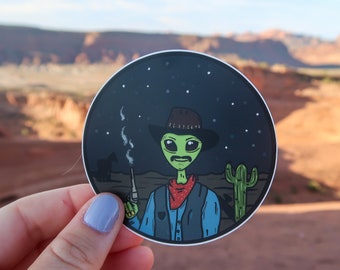 Cowboy Alien Vinyl Sticker Featuring Desert Scene and Cactus. Perfect for any Alien Lover.