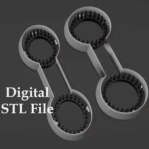Puede incluir: Dos objetos circulares grises conectados por un asa, con un anillo de puntos negros dentro de cada círculo. El texto "Digital STL File" se muestra en letras blancas en el lado izquierdo de la imagen.
