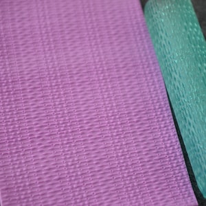 May include: A light blue textured rolling pin and a purple textured silicone mat. Both have a repeating pattern of lines and dots.