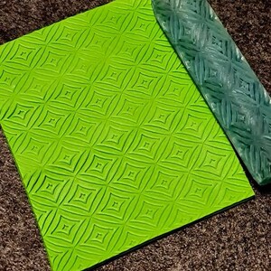 May include: A green silicone rolling pin with a diamond pattern and a matching green silicone mat with the same pattern.