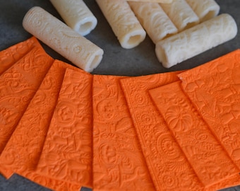 May include: Nine orange textured craft sheets with intricate patterns. The sheets are arranged in a fan shape with the top sheet partially covering the others.