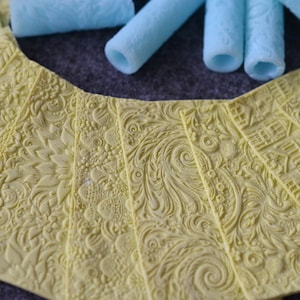 May include: A set of yellow silicone baking mats with various embossed patterns, including floral, geometric, and abstract designs.