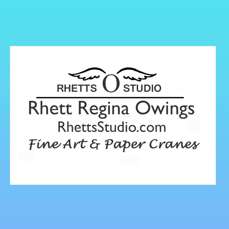 Op de afbeelding: Een witte rechthoekige afbeelding op een lichtblauwe achtergrond met de tekst "RHETTS STUDIO" boven "Rhett Regina Owings" en "RhettsStudio.com". Daaronder staat de tekst "Fine Art & Paper Cranes".