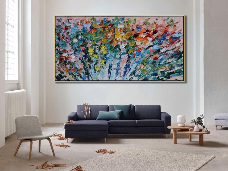 May include: Abstract painting with a colorful, textured, brushstroke style. The painting features a variety of colors, including blue, green, yellow, pink, and red. The painting is framed in a gold frame and is hanging on a white wall.