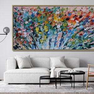 May include: Abstract painting with a colorful, textured, and brushstroke style. The painting features a variety of colors, including blue, green, yellow, orange, and red. The painting is framed in a gold frame and is hanging on a white wall.