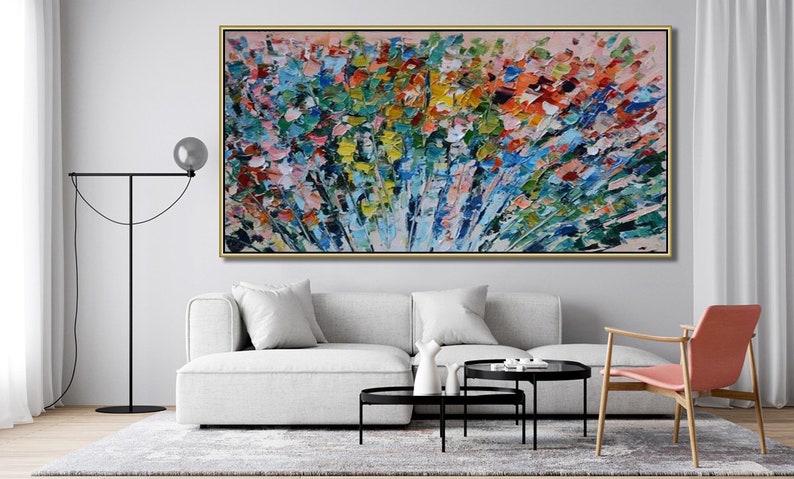 May include: Abstract painting with a colorful, textured, and brushstroke style. The painting features a variety of colors, including blue, green, yellow, orange, and red. The painting is framed in a gold frame and is hanging on a white wall.