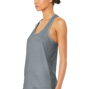 May include: A gray racerback tank top with a scoop neck. The tank top is made of a soft, comfortable fabric and has a relaxed fit.