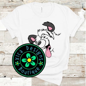 May include: White t-shirt with a cartoon dog peeking out from behind a black circle with a green flower and the text "Xica Designs Boutique".