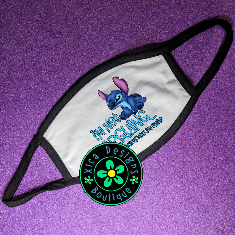 May include: A white face mask with black trim featuring a blue cartoon character and the text I'm Not ARGUING I'm Just Explaining Why I'm Right. A circular logo with a green flower and the text Xica Designs Boutique is overlaid on the mask.