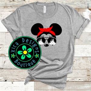 May include: Gray t-shirt with a black and white illustration of a cartoon mouse wearing red sunglasses and a red headband. The mouse is looking to the right. The text "Xica Designs Boutique" is on a green and yellow flower graphic.