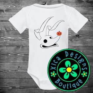 May include: A white short-sleeved baby bodysuit featuring a black line art graphic of a ghost dog with long ears and a small orange jack-o'-lantern on its nose. A circular logo with the text Xica Designs Boutique and a green flower is present.