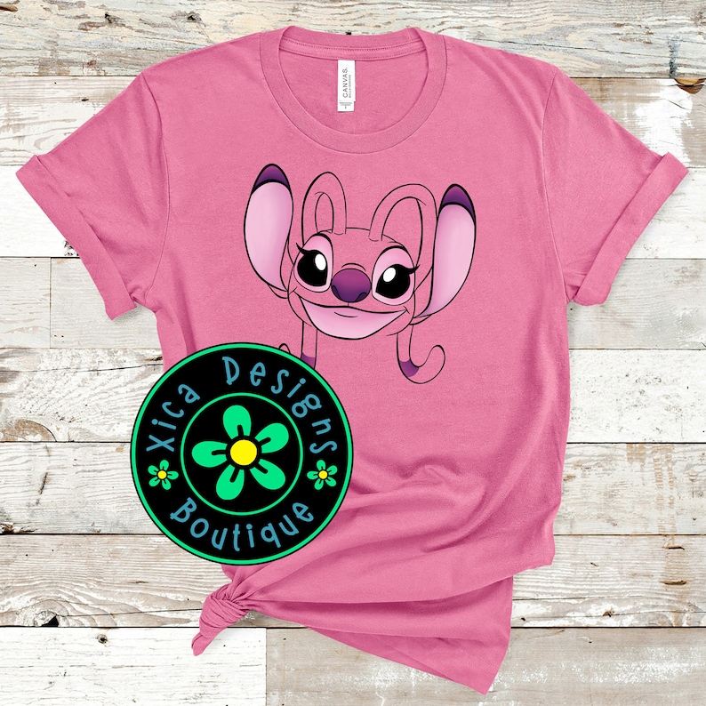 Puede incluir: Camiseta rosa con una imagen de dibujos animados de Stitch de Lilo & Stitch. La imagen est&aacute; en el centro de la camiseta. La camiseta tiene un peque&ntilde;o logotipo en la esquina inferior izquierda que dice "Xica Designs Boutique" con una flor verde.