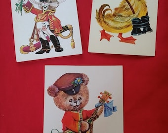 May include: Three vintage postcards featuring cartoon animals dressed in military uniforms. The first postcard shows a rabbit in a red and gold uniform holding a bouquet of flowers. The second postcard shows a duck in a blue sailor uniform. The third postcard shows a teddy bear in a red and gold uniform playing a stringed instrument. The text on the first postcard reads "Поздравляю!" which translates to "Congratulations!" in English.