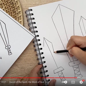May include: A spiral-bound sketchbook featuring black-and-white line drawings of three swords, with a hand using a grey pencil to draw a fourth sword. Beside it, a printed sheet displays a sword illustration and text about the Sword of the Spirit.