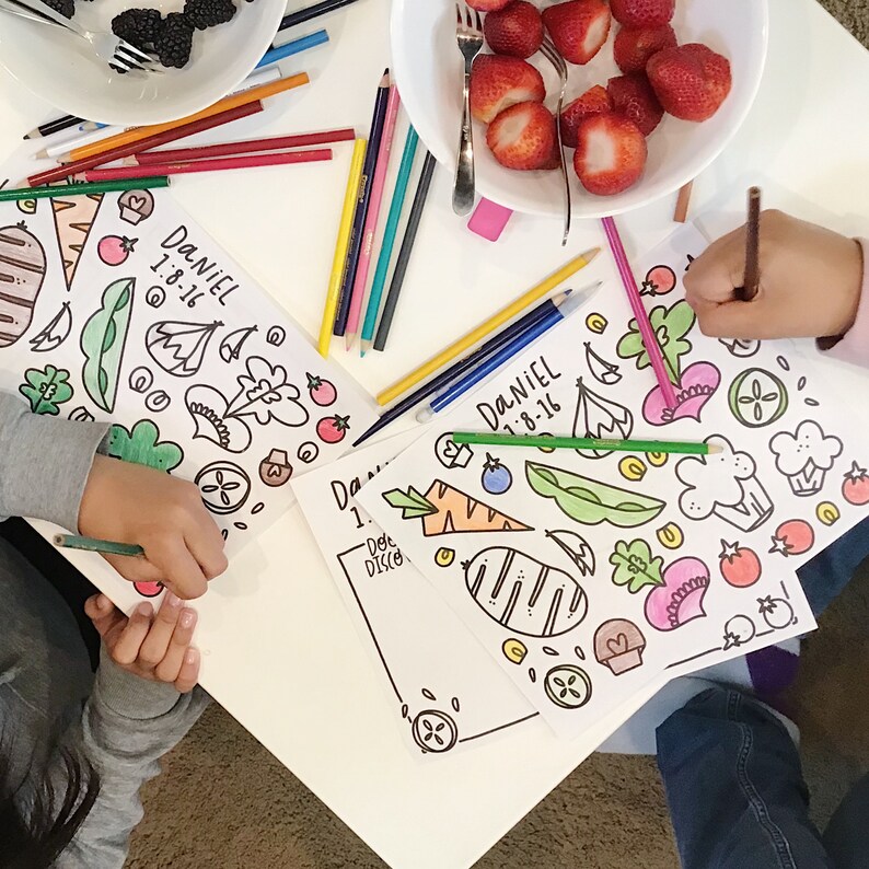 Peut inclure: Deux enfants colorent des pages &agrave; colorier avec des crayons. Les pages &agrave; colorier pr&eacute;sentent une vari&eacute;t&eacute; de l&eacute;gumes et de fruits. Les pages sont intitul&eacute;es "Daniel 1-8-16".