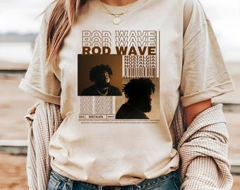 Könnte beinhalten: Ein beiges Kurzarm-T-Shirt mit einem Grafikdruck von Rod Wave. Das Design enthält den Text ROD WAVE und NOSTALGIA, einen Strichcode sowie zwei fotografische Porträts des Künstlers in dunklen Tönen vor hellem Hintergrund.