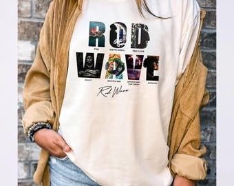 Könnte beinhalten: Cremefarbenes T-Shirt mit dem Schriftzug "ROD WAVE" in einem stilisierten Design, darunter Albumtitel. Das Shirt hat einen Rundhalsausschnitt und kurze Ärmel. Das Design enthält Bilder und Text, die sich auf die Musik des Künstlers beziehen.