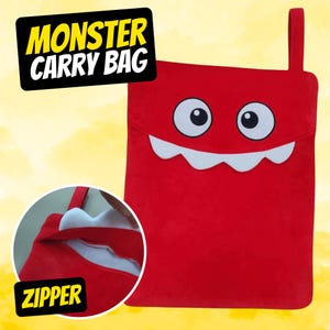 May include: Red monster carry bag with a zipper opening and a white toothy grin. The bag has the words "Monster Carry Bag" printed in yellow on the top.