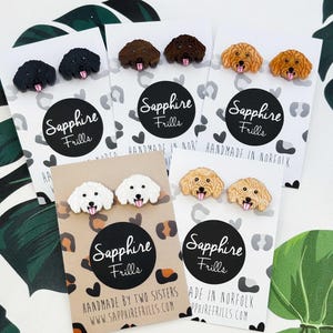 以下が含まれることがあります： 黒、茶色、ブロンドの犬の形をしたスタッドピアス。各ペアは、「Sapphire Frills」の文字と「Handmade in Norfolk」のフレーズが書かれたカードに表示されています。魅力的なアクセサリーです。