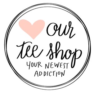 May include: A black and white circle with a pink heart and the text "Our Tee Shop Your Newest Addiction".