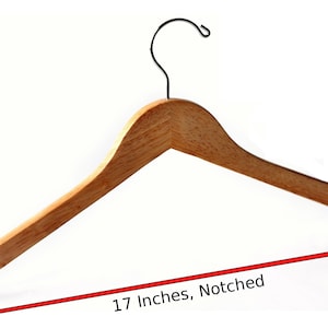 Puede incluir: Una percha de madera natural con un gancho de metal negro. La percha mide 43 cm de largo y tiene un extremo con muescas.