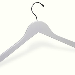 Puede incluir: Percha de madera blanca con un gancho de metal plateado.