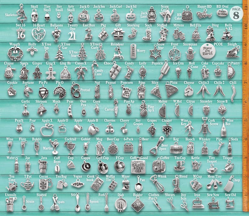 Puede incluir: Una colecci&oacute;n de dijes de metal plateado dispuestos en una cuadr&iacute;cula sobre un fondo verde azulado, con varias formas que incluyen comida, s&iacute;mbolos festivos y art&iacute;culos del hogar, con una regla vertical de 25,4 cm en el lado derecho.