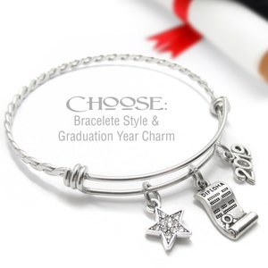 May include: Silver charm bracelet with a graduation cap, diploma, and star charm. The bracelet has a braided design and says "CHOOSE: Bracelet Style & Graduation Year Charm".