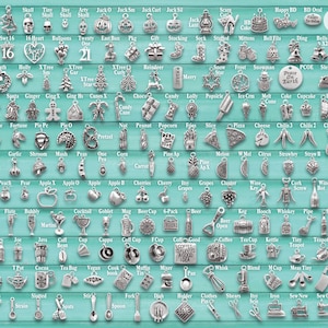 May include: A collection of silver-toned metal charms arranged in a grid on a teal background, featuring various shapes including food, holiday symbols, and household items, with a vertical ruler on the right side showing 10 inches of length.
