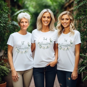 May include: Three women wearing white t-shirts with gold floral wreaths and the text "1st Generation", "2nd Generation", and "3rd Generation".