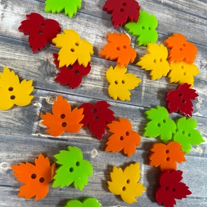 May include: Assortment of colourful leaf-shaped buttons in red, orange, yellow, and green.