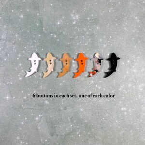 May include: Six colourful fish-shaped buttons, one of each colour: white, beige, light brown, orange, black and white, and black.  6 buttons in each set, one of each colour.