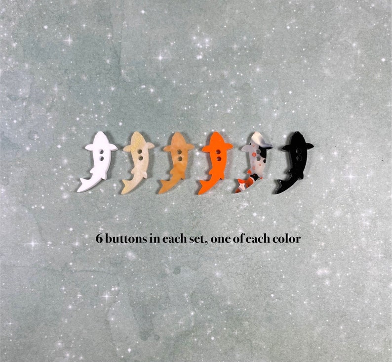 May include: Six colourful fish-shaped buttons, one of each colour: white, beige, light brown, orange, black and white, and black.  6 buttons in each set, one of each colour.