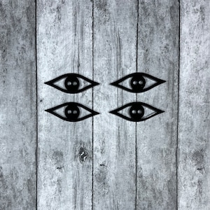 May include: Four black stylized eyes with two pupils each, arranged in two rows of two, on a gray wood background.