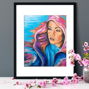 May include: A painting of a woman with long, flowing hair, wearing a pink and blue hooded garment. The background is a vibrant blue and purple.