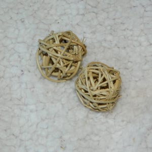 May include: Two spherical decorative orbs constructed from interwoven light brown natural twigs. The spheres feature an open, airy lattice design created by the crisscrossing of thin, flexible wooden strips, resulting in a textured, organic appearance.