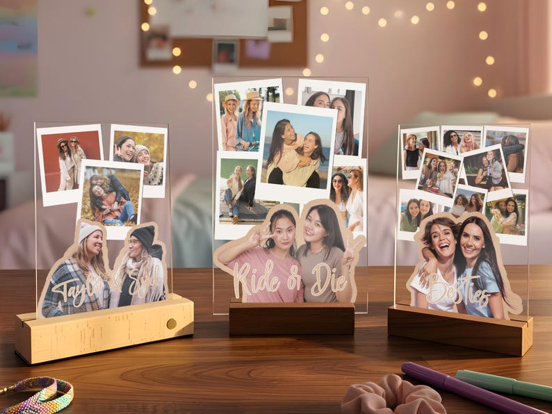 May include: Three clear acrylic photo display stands with wooden bases, each featuring multiple printed polaroid-style photos and custom text cutouts including "Taylor & Sky," "Ride & Die," and "Besties" layered over the images.