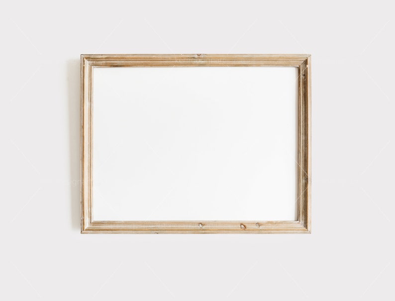 May include: A rectangular, gold-colored picture frame with a white interior. The frame has a distressed, vintage appearance, with visible wood grain and slight imperfections. The frame is empty, ready for a photo or artwork.