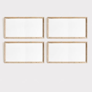 May include: Four rectangular wooden picture frames with white mats and blank white spaces inside. The frames are arranged in a grid pattern on a white wall.