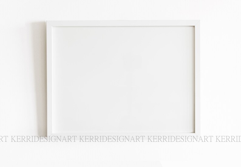 May include: A white picture frame with a white mount. The frame is on a white wall.