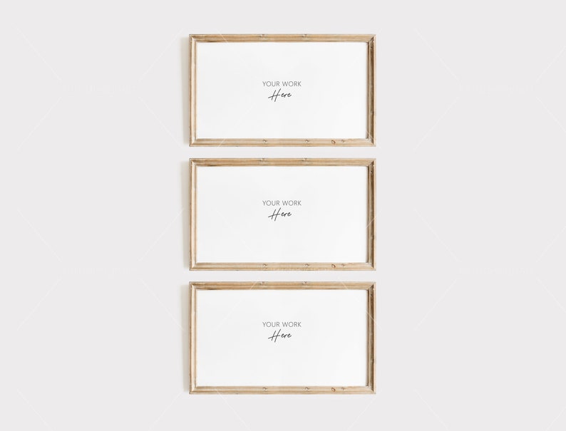 Op de afbeelding: Drie rechthoekige houten fotolijsten met witte interieurs worden verticaal weergegeven. Elke lijst heeft een lichte, natuurlijke houtnerf. De tekst "YOUR WORK Here" is in cursieve letters in het midden van elk frame geschreven.