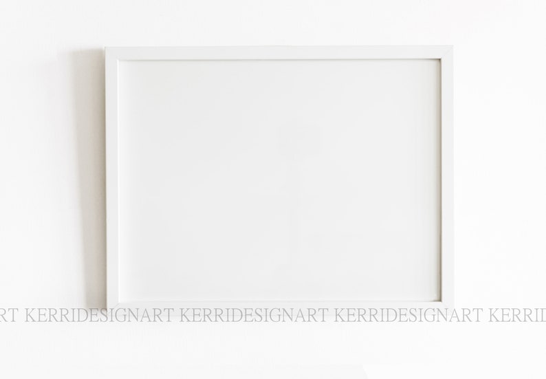May include: A white picture frame with a white mount. The frame is on a white wall.