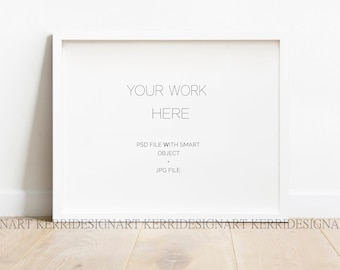May include: White picture frame mockup with the text "YOUR WORK HERE" and the text "PSD FILE WITH SMART OBJECT JPG FILE" on a white wall with a light wood floor.