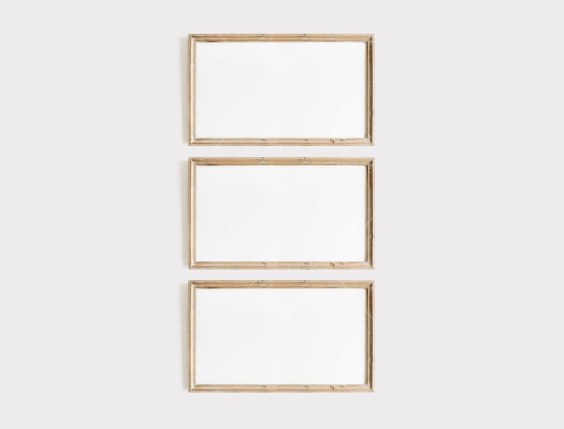 Op de afbeelding: Drie rechthoekige houten fotolijsten met witte binnenkanten zijn verticaal gerangschikt tegen een witte achtergrond. De frames hebben een natuurlijke houtnerf afwerking en de algehele esthetiek is minimalistisch en schoon, geschikt voor het weergeven van kunst of foto's.